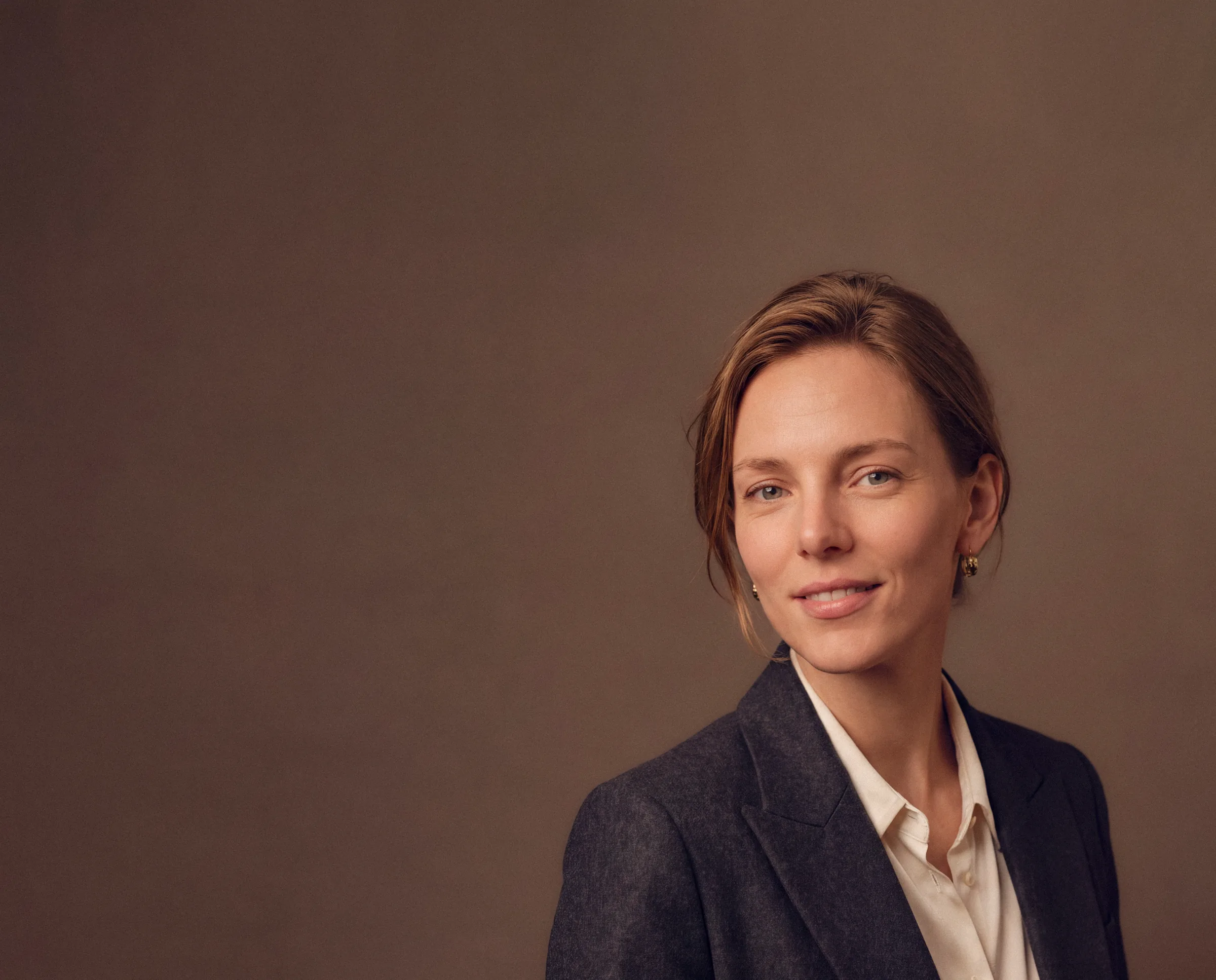 Portrait corporate d'une femme en blazer sur fond brun — photographe d'entreprise à Paris