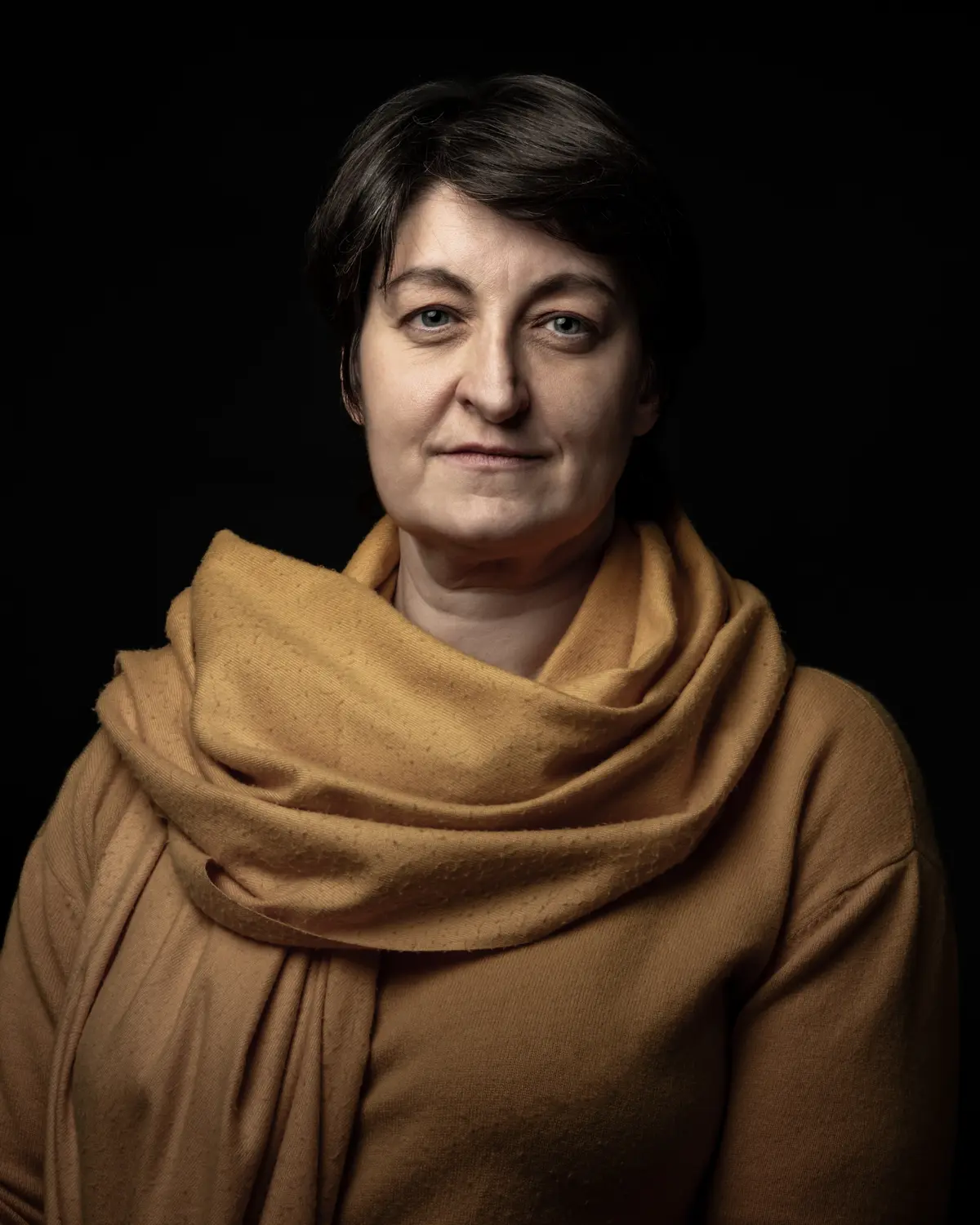 Portrait corporate d'une collaboratrice, fond sombre, studio mobile