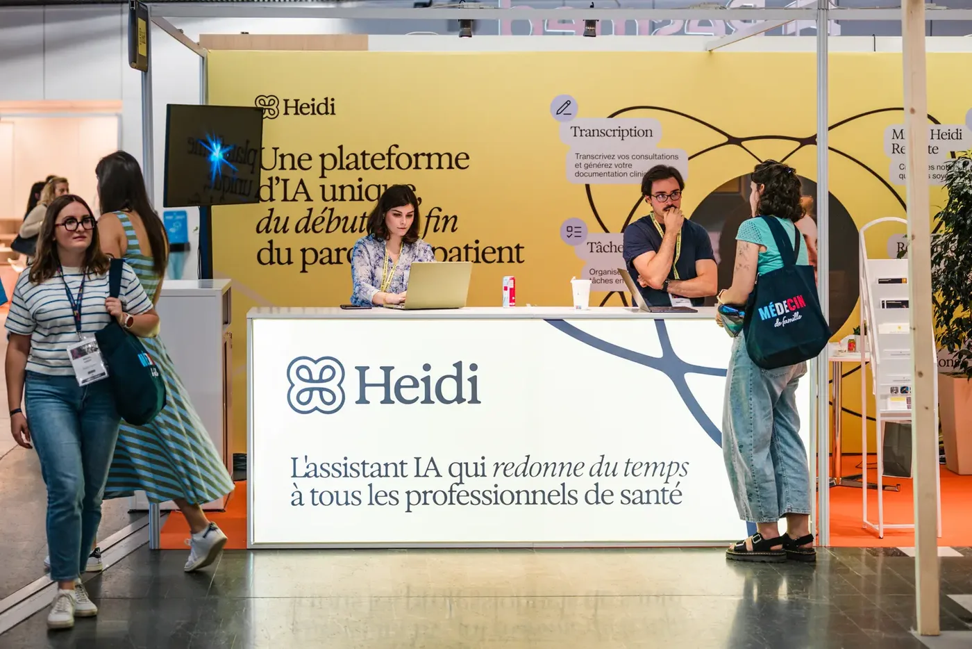 Échanges entre participants devant un stand d'exposant