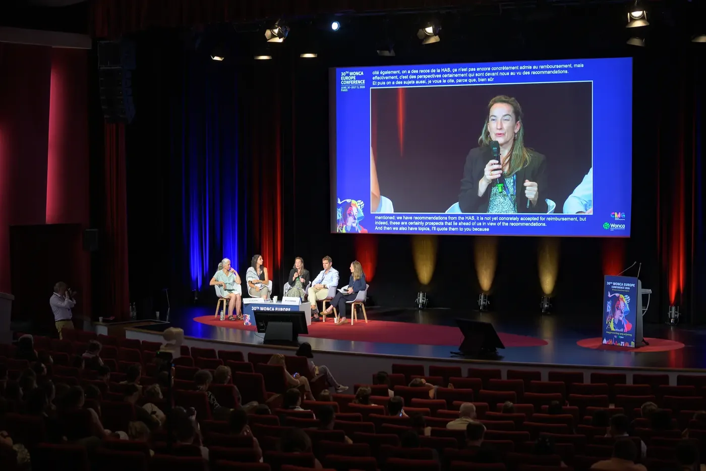 Plénière d'un séminaire d'entreprise, intervenant sur scène devant la salle