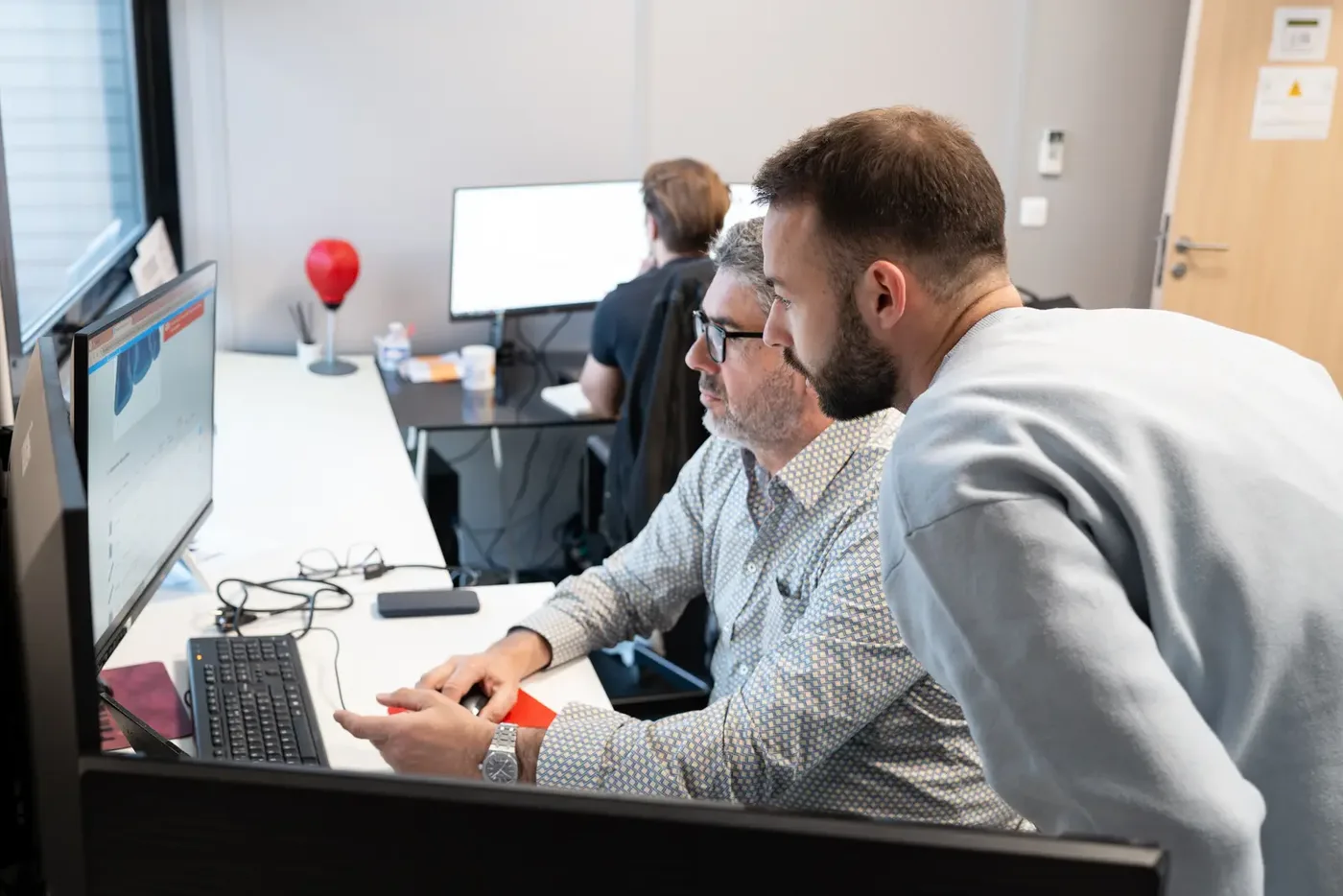 Équipe en séance de travail autour d'un poste informatique