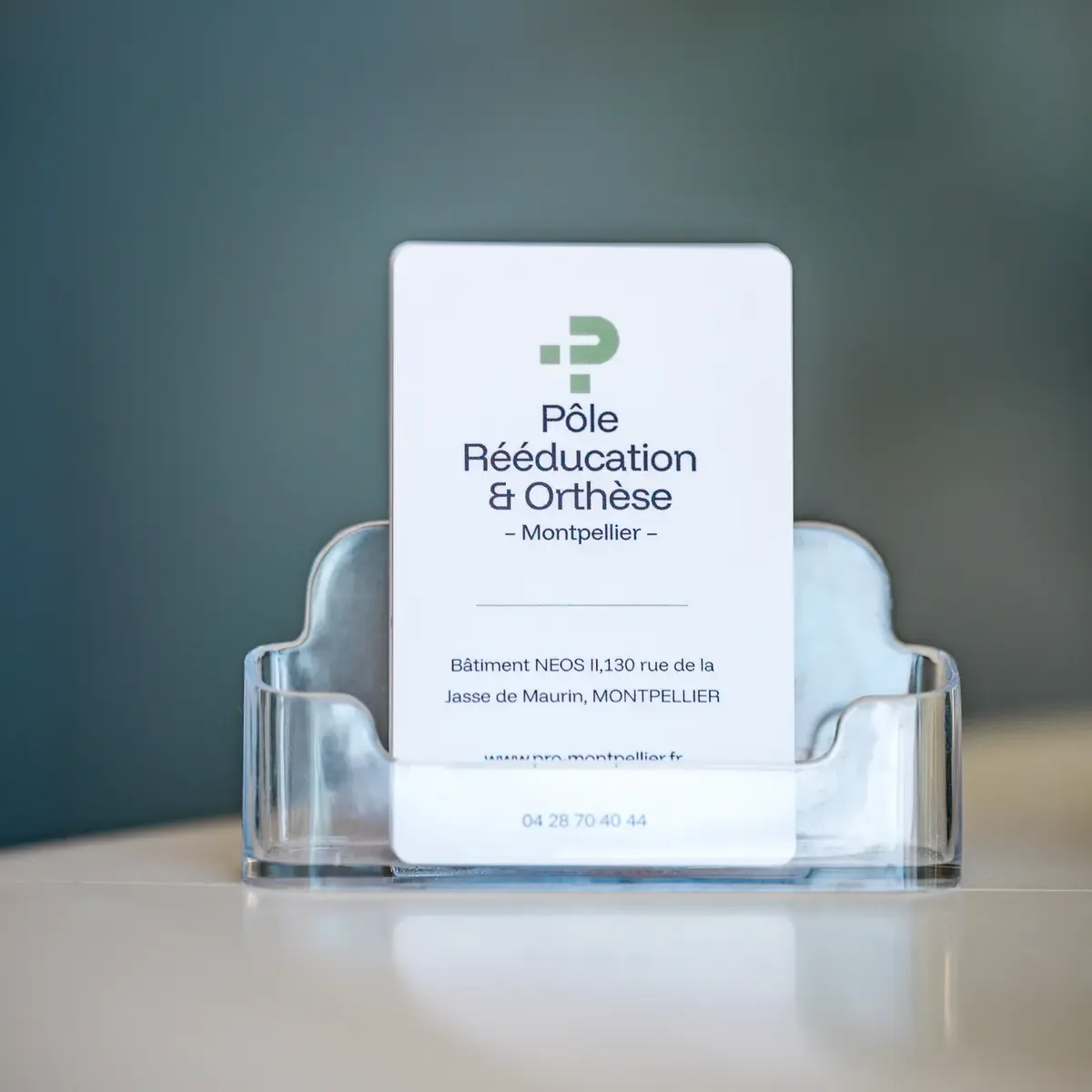 Carte de visite du Pôle Rééducation & Orthèse sur le comptoir d'accueil